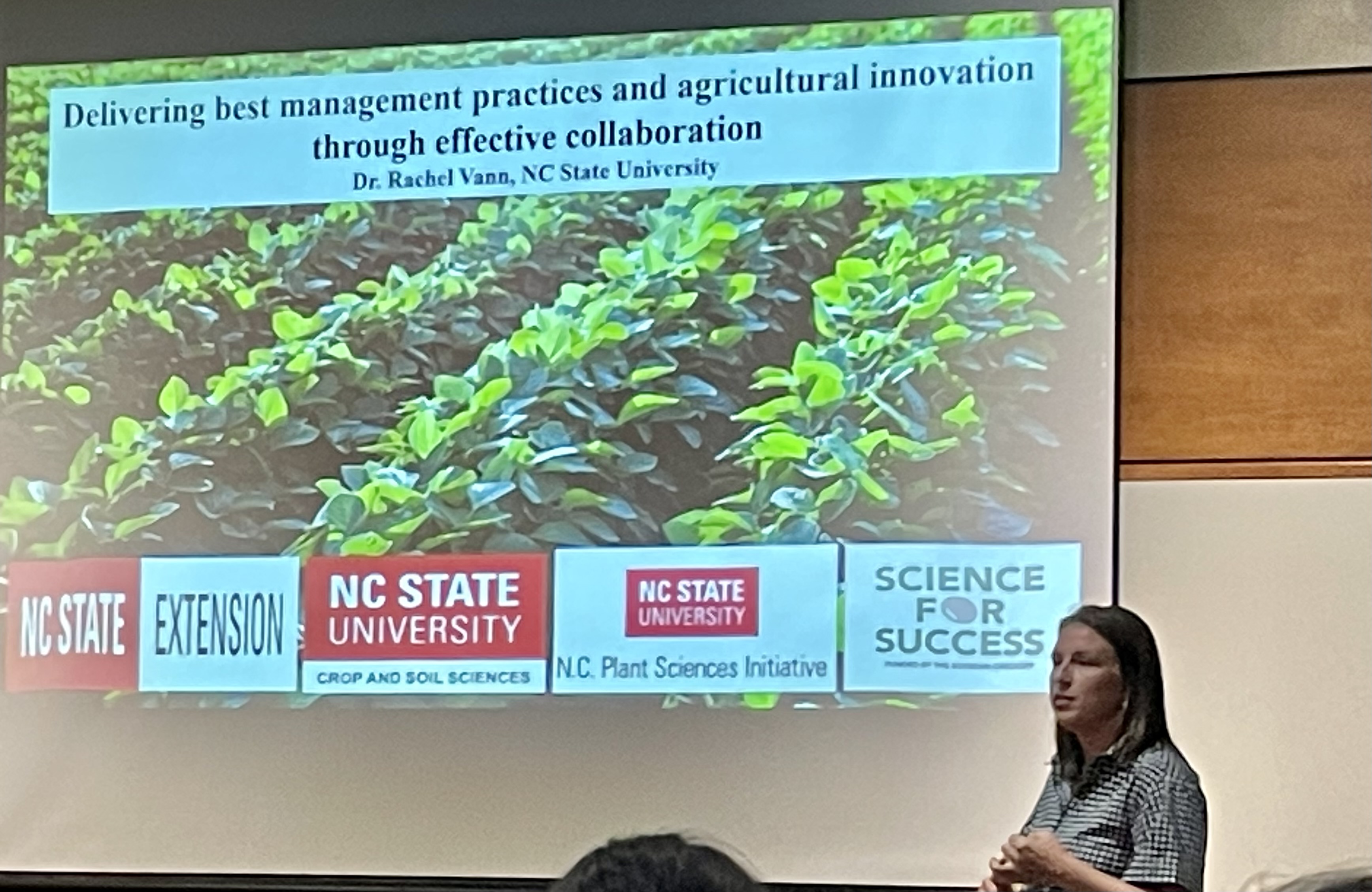 Rachel Vann gives a seminar in front of an image of soybean plants