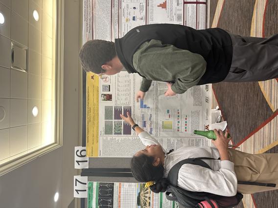 MJay Espina and Lucas Roberts stand in front of MJay's scientific poster. 